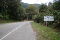 Fotografia 87: Aspectos da Estrada-Parque com a Serra do Guararu ao fundo e à direita a placa de indicação do centro de capacitação da Adelg.