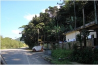 Fotografia 06: Moradia na lateral direita da Rodovia Guarujá-Bertioga. A existência de materiais de construção indica pressão de ocupação.